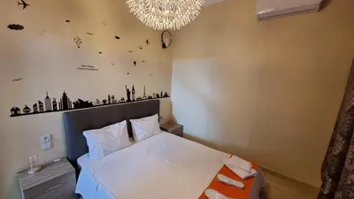 a bedroom with a bed and a chandelier at Enjoy Sunset in Palaiochóra