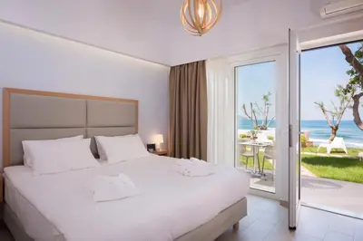 a bedroom with a bed with a view of the ocean at Hermes Beach Front in Stalos