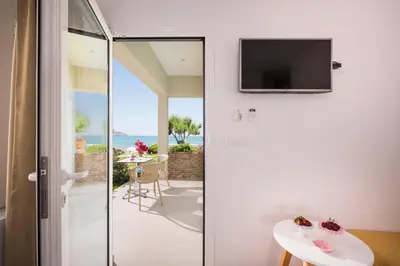 a room with a sliding glass door with a view of the ocean at Hermes Beach Front in Stalos
