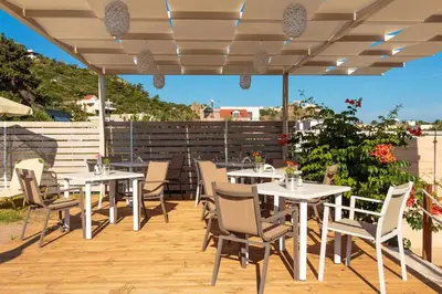 a patio with tables and chairs on a deck at Charming and Comfy House in Agia Marina Nea Kydonias
