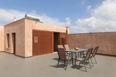 a patio with a table and chairs on a roof at Polixeny's Suites in Chania Town
