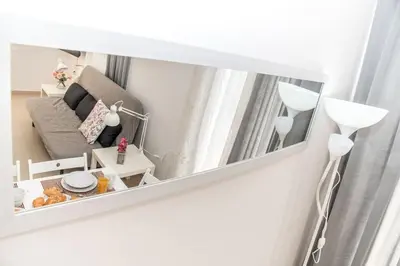 a mirror reflecting a living room with a couch at Nikis Apartment in Chania Town