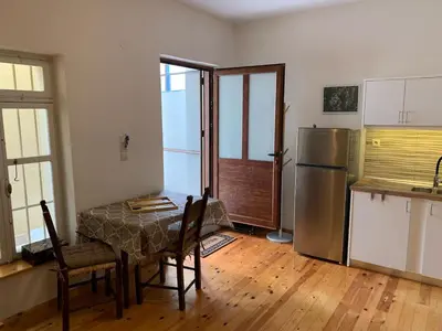 a kitchen with a table and a stainless steel refrigerator at Tastefully Decorated One-bedroom Apartment - Chania in Chania Town