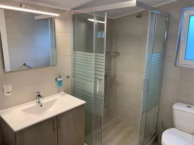 a bathroom with a sink and a glass shower at Tastefully Decorated One-bedroom Apartment - Chania in Chania Town