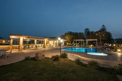 a patio with a swimming pool in front of a building at Captain's Beach Apartments in Kissamos