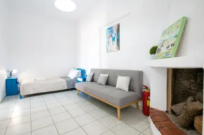 a living room with a couch and a bed at Captain's Beach Apartments in Kissamos
