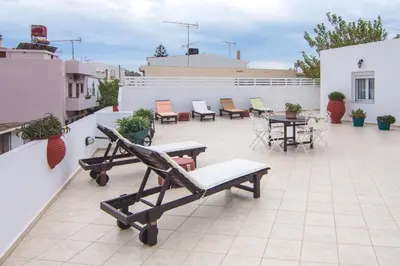 a patio with chairs and tables on a roof at Manto Studios in Palaiochóra