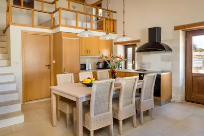 a kitchen with a wooden table and chairs at Olga's Filoxenia - Villa Aladanos-private pool and heated jacuzzi in Makhairoí