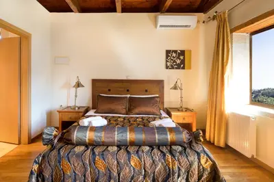 a bedroom with a large bed and a window at Olga's Filoxenia - Villa Aladanos-private pool and heated jacuzzi in Makhairoí