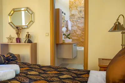 a bedroom with a bed and a mirror at Olga's Filoxenia - Villa Aladanos-private pool and heated jacuzzi in Makhairoí