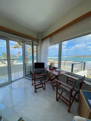 a living room with a table and chairs and the ocean at Sea Breeze in Kalamaki Chanion