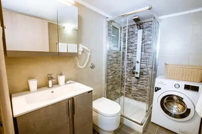 a bathroom with a sink and a washing machine at Raimonda's House in Chania Town
