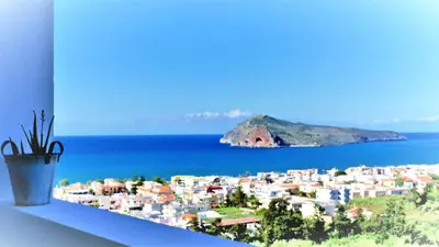 a window sill with a view of a city and the ocean at Thea Apartment in Agia Marina Nea Kydonias