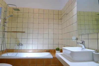 a bathroom with a white tub and a sink at Maria & Manos Guest House, Agios Onoufrios beach in Agios Onoufrios