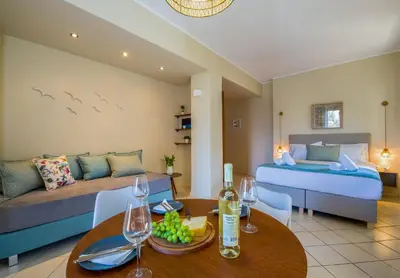 a room with a bed and a couch and a table at Gianthea Studios and Apt in Stalos