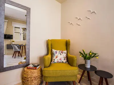 a yellow chair in a living room with a mirror at Gianthea Studios and Apt in Stalos