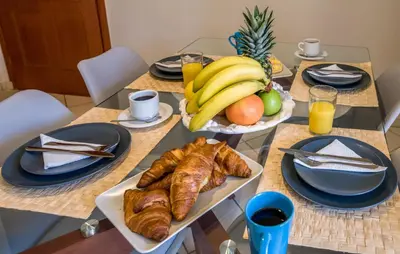 a table with a breakfast of croissants and fruit at Gianthea Studios and Apt in Stalos