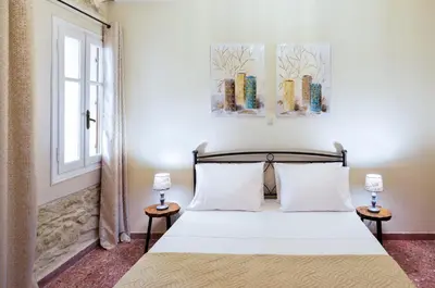 a bedroom with a bed with two night stands next to a window at Michalis Stonehouse in Chania Town