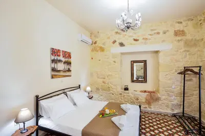 a bedroom with a bed and a stone wall at Michalis Stonehouse in Chania Town