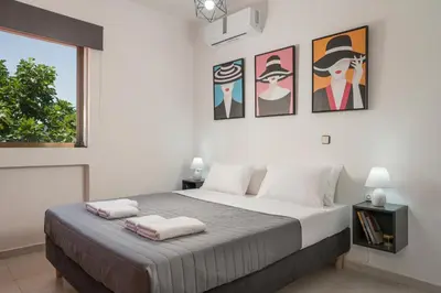 a bedroom with a large bed with pictures on the wall at Villa Aphrodite in Alikianós