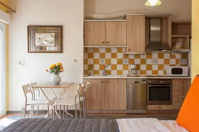 a kitchen with a table and chairs in a room at Evelia Apartment in Galatás