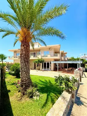 a palm tree in front of a building at Avenue Hotel Falassarna in Falasarna