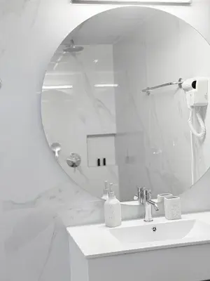 a white bathroom with a sink and a mirror at Avenue Hotel Falassarna in Falasarna