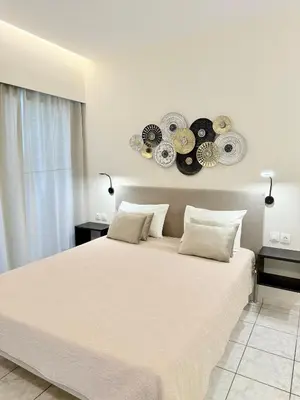 a bedroom with a large bed with clocks on the wall at Avenue Hotel Falassarna in Falasarna