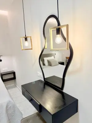a bedroom with a black table and a mirror at Avenue Hotel Falassarna in Falasarna