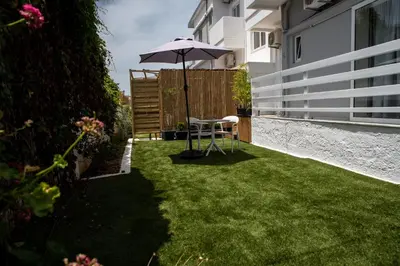a lawn with an umbrella and a chair in a yard at Eloque Simple living space in Kato Daratso
