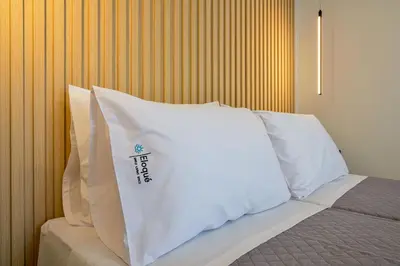 a bed with white pillows on top of it at Eloque Simple living space in Kato Daratso