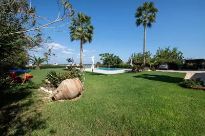 a park with palm trees and a swimming pool at Socrates Holidays Apt 4 with Pool near the Beach in Kamisianá