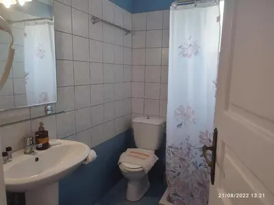 a bathroom with a toilet and a sink and a shower curtain at Villa Giorgos in Plataniás