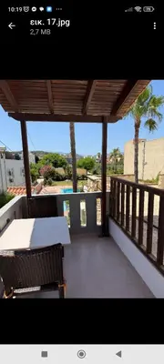 a patio with a table and chairs on a balcony at Villa Giorgos in Plataniás