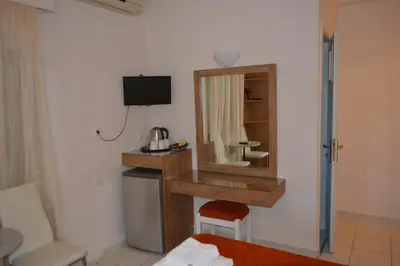 a hotel room with a mirror and a bed at Hotel Lefka Ori - City Rooms in Chania Town