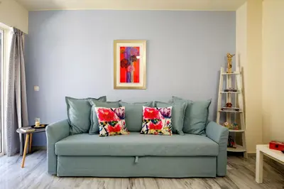 a blue couch with pillows in a living room at Melina Apartments in Chania Town