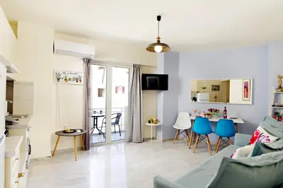 a living room with blue chairs and a table at Melina Apartments in Chania Town