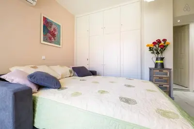 a bedroom with a large bed with a vase of flowers at Melina Apartments in Chania Town