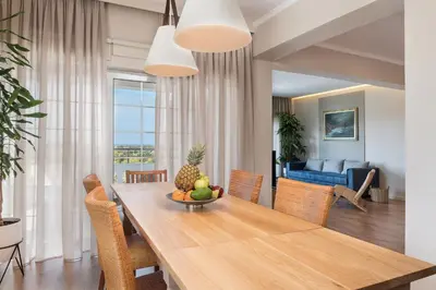 a dining room and living room with a table and chairs at Anemone Holiday Apartment in Kato Daratso