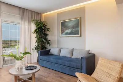 a living room with a blue couch and a table at Anemone Holiday Apartment in Kato Daratso