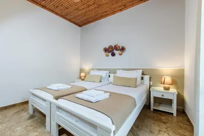 a bedroom with two beds and a wooden ceiling at Evelinas House Platanias in Plataniás