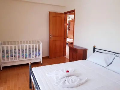 a bedroom with a white bed with a crib at Eftihia's Traditional House in Loúlos