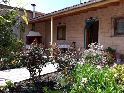 a garden in front of a house with flowers at Eftihia's Traditional House in Loúlos