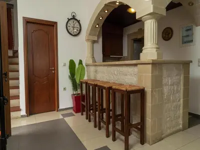 a kitchen with a counter with stools and a clock on the wall at Modern holiday home in Stalos with balcony in Stalos