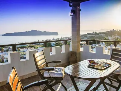 a table and chairs on a balcony with a view of the ocean at Modern holiday home in Stalos with balcony in Stalos