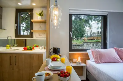 a room with a bed and a table with food on it at Nest of Marmel Luxury Studio in Chania Town