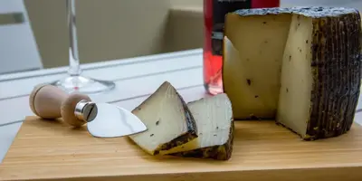 a piece of cheese sitting on a cutting board at Nest of Marmel Luxury Studio in Chania Town