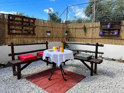 a table and two benches with a table and chairs at Antigoni's Studio Cozy Private Apartment in Kissamos