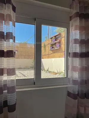 a window in a room with two windows with curtains at Antigoni's Studio Cozy Private Apartment in Kissamos