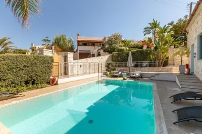a swimming pool with blue water in a house at Superior Villa Kleanthi in Stalos